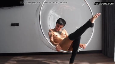 Татуированная голая фитнес тренерша гнется во время йоги