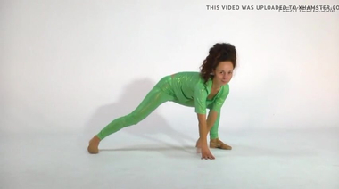 Загорелая гимнастка тянется в латексе и голышом на коврике для йоги