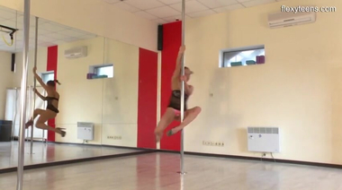 Русская гимнастка учится стриптизу у шеста в танцевальном зале